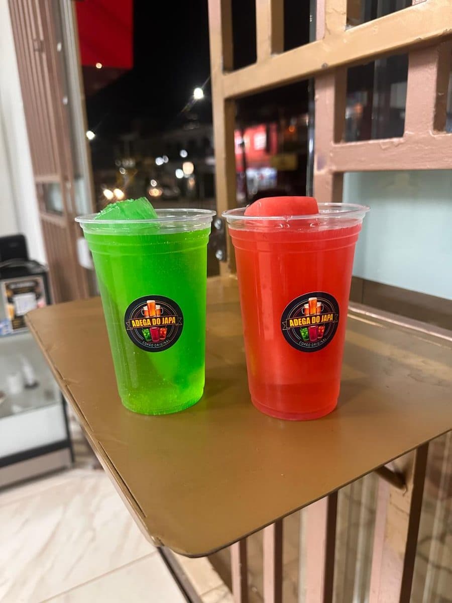 Dois copões gelados da Adega do Japa, um verde e outro vermelho, com pedra de gelo colorida